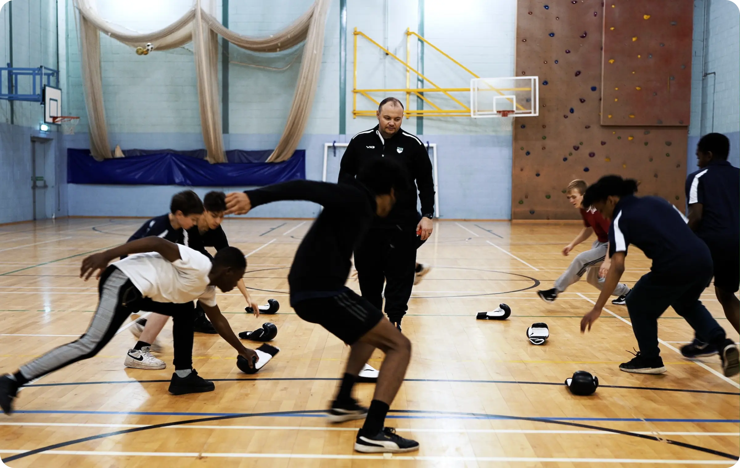 A coach training youth in boxing techniques in a community sports setting
